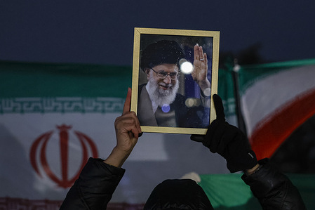 A demonstrator holds a framed portrait of Iran’s Supreme Leader Ayatollah Ali Khamenei during an anti-war protest outside the White House, opposing U.S. and Israeli military strikes on Iran. President Donald Trump announced that the United States and Israel had launched an attack on Iran on Saturday morning.