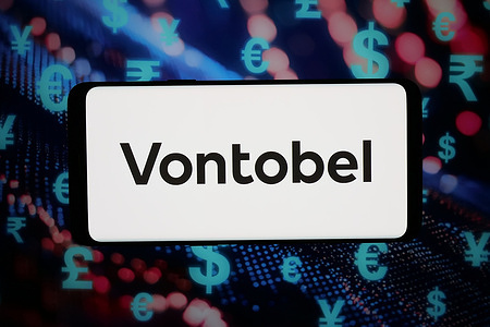 In this photo illustration, the logo of Swiss investment company Vontobel Holding AG is displayed on a smartphone in front of abstract background on computer screen.