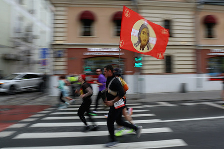 Amateur athletes with Orthodox flag seen during the Moscow Half Marathon at the Bolshaya Ordynka street. The Moscow Half Marathon 2026 hold in cold and rainy weather on the last Sunday of April and brings together more than 15,000 participants.