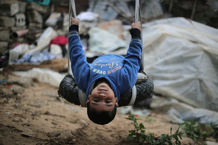 A Palestinian child plays on a swing in the Khan Younis refugee camp in the southern Gaza Strip.
