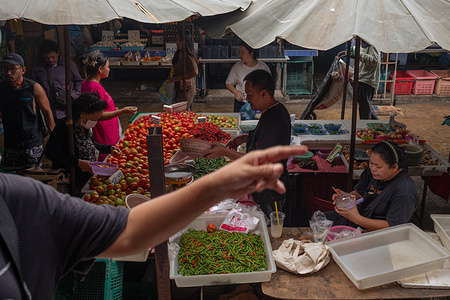 People buy vegetables at a stall in Bang Kapi Fresh Market.