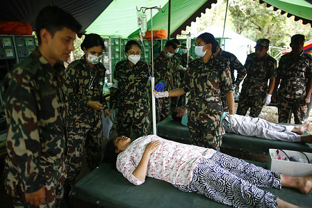 An army medical team treats survivors rescued from the floods at an army camp in Nuwakot.