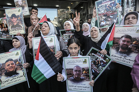 Families of Palestinian prisoners hold portraits of their detained relatives during a solidarity rally in the city of Nablus, in the northern occupied West Bank. Palestinians staged a protest to demand a prisoner exchange agreement with the Israeli government and Hamas.