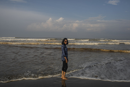 A woman poses for a photo at the Cox's Bazar sea beach. 
Cox's Bazar sea beach is 152 km from Chittagong city to the south and is 414 km from Dhaka. It is the largest tourist destination in Bangladesh. Plans are afoot to set up a railway line from Chittagong to Cox's Bazar