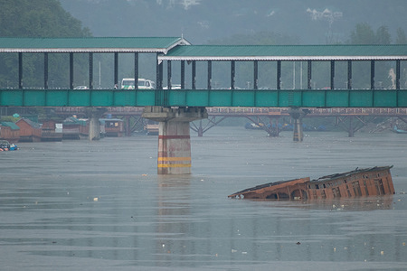 A drowned houseboat is seen in River Jhelum during heavy rainfall. Due to the impact of back-to-back active Western Disturbances as cyclonic circulation, Jammu and Kashmir is going to receive moderate to heavy rainfall during the next 48hrs. Moderate to heavy snowfall is also expected over the higher reaches of the valley.