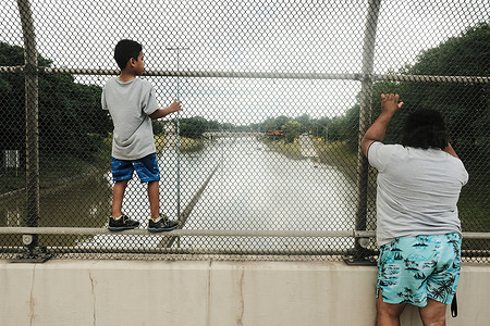 Detroit residents observe a stretch of I-94 that is still under several feet of water following heavy weekend rains which flooded parts of Metro Detroit.
After a weekend of heavy storms beginning on Friday night and lasting through the weekend rainwater flooded parts of I-94 in Detroit, Michigan forcing some motorists to abandon their vehicles and seek shelter from the heavy rains. Flood waters remained in areas along I-94 between Dearborn and Downtown Detroit several days later as Michigan Governor Gretchen Whitmer held a press conference on the still inundated I-94.