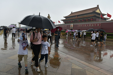 A tourist family uses an umbrella during a visit to Tiananmen Square on a rainy day.
The Beijing Meteorological Observatory upgraded its orange rainstorm warning signal, temporarily cut off several roads, shut down some trains and cancelled some flights.