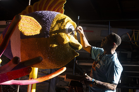 A volunteer works on a float for the 137th Rose Parade in Pasadena. Better known as the Rose Parade, the festival of flower-covered floats will take place on Jan. 1, 2026.