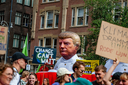 An inflatable Trump is seen observing the climate activists passing by. Thousands of people gathered in the center of Amsterdam to send a message: "Take action and swap fossil fuels for renewable sources" to Prime Minister Rob Jetten. This demonstration is an initiative of the Climate Crisis Coalition (Oxfam Novib, FNV, Fridays For Future, Greenpeace Netherlands, Extinction Rebellion, Fossielvrij NL, Milieudefensie, and DeGoedeZaak). According to the organization, about 40,000 people turned out.