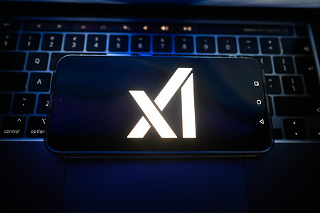 In this photo illustration, the Xai logo is seen displayed on a smartphone on the top of a laptop.