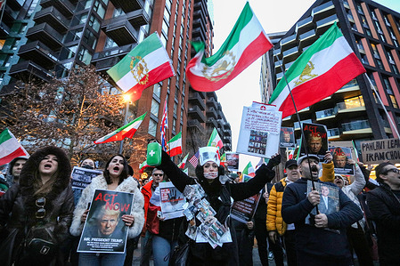 Protesters wave pre-1979 Iranian flags and "Act Now" President Trump signs during the demonstration. People take part in a rally in solidarity with protesters in Iran congregating outside the United States embassy. Protesters are calling on the British government and the United States government to support Iranians as anti-government protests continue across Iran. The demonstrations have followed economic troubles in the country, and the regime has shut down the internet and arrested and killed many protesters. Iranians living in London are demanding an end to the violence and repression of demonstrations against the Iranian government.