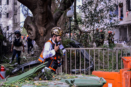 Paramedics search in a direct hit site of an Iranian ballistic missile in a residential neighbourhood.