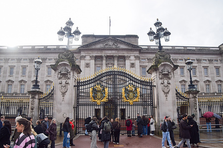 General view of Buckingham Palace with tourists gathering outside.