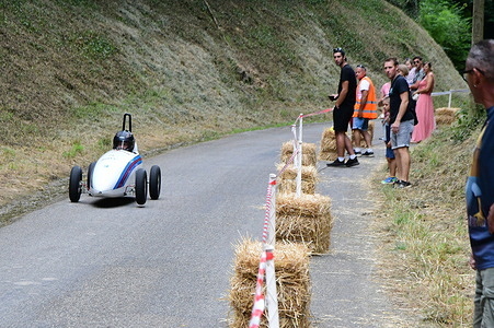 A participant-built vehicle seen during the soapbox race. The soapbox race, organized by the Alps committee of the French Soapbox Racing Federation and the La Saint-Lazare association, features gravity-powered, motorless cars racing downhill. Participants build their own creative and often whimsically themed vehicles, with teams judged not only on speed but also on design and showmanship. Safety is a key concern, and the event serves as a festive community gathering that attracts both racers and spectators.