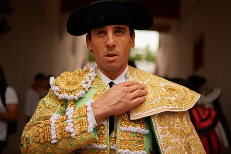 Juan Ortega puts on his bullfighter's cape before going out to fight in the Pamplona Bullring during the 2025 San Fermín festivities.