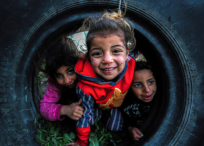 Palestinian children play in front of their house during the cold weather on the outskirts of Khan Yunis refugee camp in the southern Gaza Strip.
