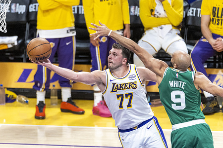 Los Angeles Lakers’ Luka Dončić (77) goes past Boston Celtics’ Derrick White (9) to the basket during an NBA basketball game at Crypto.com Arena on Sunday, Feb. 22, 2026 in Los Angeles.