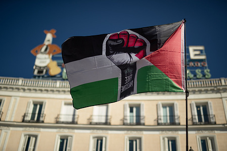 A Palestinian flag with a fist in the center waves during a pro-Palestine demonstration at Puerta del Sol in Madrid, organized by the Solidarity Network Against the Occupation of Palestine (RESCOP) and the "End the Arms Trade with Israel" Campaign. Campaigns still continue to take place in several Spanish cities, despite Prime Minister Pedro Sánchez's announcement of an arms embargo on Israel and an entry ban on those involved in genocide.