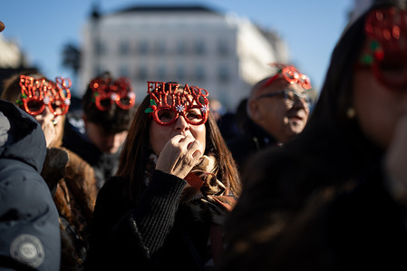 Several people eat the traditional grapes during the traditional "pre-New Year's Eve" celebrations in Madrid's Puerta del Sol square. This event takes place every December 31st at noon, during the rehearsal for the midnight chimes, a moment when families and friends take the opportunity to toast the new year.
