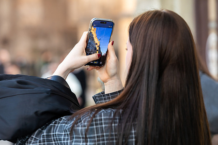 A woman is seen recording the architecture of the Opera House (not in a view) with a smartphone. The daily life of Lviv maintains its familiar rhythm, becoming a form of quiet and stubborn defiance against external aggression. On the sunlit streets, peaceful scenes are closely intertwined with the harsh reality of war, where moments of tranquility are repeatedly interrupted by air raid sirens and the threat of missile strikes. The city continues to breathe and endure, proving that the will to live and loyalty to one's values are stronger than the fear of drones, enemy missiles, and destruction.