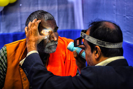 A doctor checks the eyesight of a pilgrim at a free camp at Gangasagar Transit Camp in Kolkata, India.