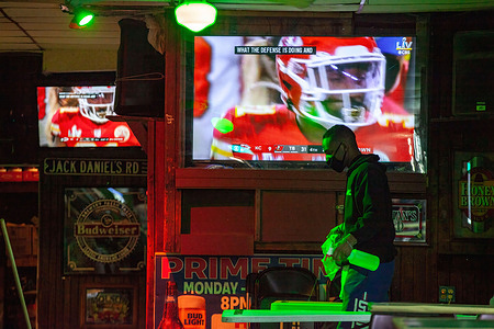 Bartender of Lucky’s Sports Tavern seen cleaning during the Super Bowl LV march between the Kansas City Chiefs and the Tampa Bay Buccaneers. 
Students and residents of Athens, Ohio watch the Kansas City Chiefs and the Tampa Bay Buccaneers square off in Super Bowl LV under COVID-19 restrictions in bars.
