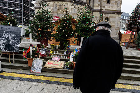 A visitor looks at the memorial for the victims of the terrorist attack on the Christmas market in 2016 as the Christmas market on Breitscheidplatz opens its doors for visitors for the 34th time today, around 1 year after (19 December 2016), the Islamist assassin Anis Amri drove a truck in the crowd of the market and killed eleven visitors.