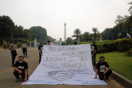 Protesters dressed in black t-shirts hold a huge banner during the demonstration.
Protesters gathered at the National Monument demanding President Joko Widodo to revoke the Omnibus Law on the Job Creation Law and its derivative regulations that remove Ash Bottom Ash (FABA) from the list of B3 waste.