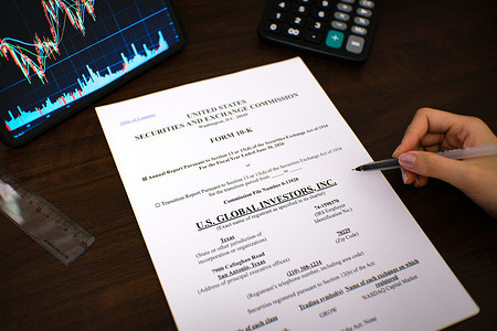 In this photo illustration, a woman (not fully in view) seen reviewing the Form 10-K annual report of U.S. Global Investors, Inc. for the fiscal year ended June 30, 2026.