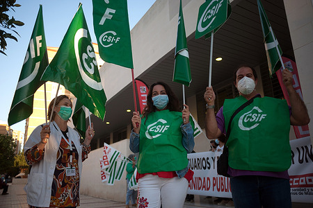 Protesters wearing face masks hold flags outside the 'Huelin' medical center during the demonstration.
Several trade unions of the health sector claim for better conditions for the primary health centres and their healthcare workers. Medical centres have been overloaded as infections increased due to the coronavirus pandemic and exposing the shortcomings of the public health system.