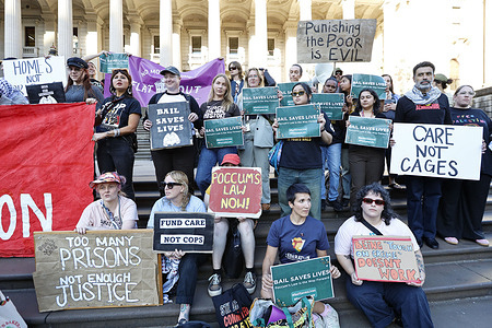 Protesters hold placards during the rally.  The protest at Parliament steps calls for the abolition of “tough on crime” laws and advocates for Poccum’s Law which supports granting bail to those awaiting trial. The rally highlights the disproportionate impact of these laws on Aboriginal women, trans and gender-diverse individuals urging legal reforms to prioritize fairness and justice. Historically, Aboriginal communities have been overrepresented in the criminal justice system with systemic issues that perpetuate disadvantage.