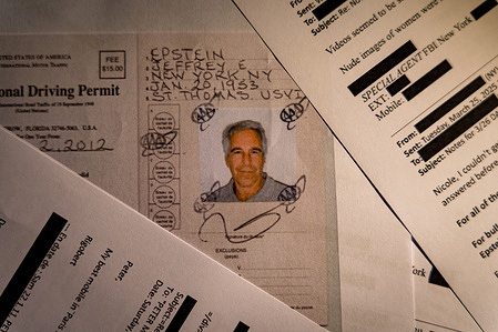 A document that was included in the U.S. Department of Justice release of the Jeffrey Epstein files, showing Jeffrey Epstein International Driving License, is seen photographed on a desk.