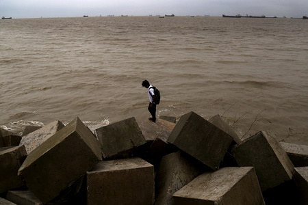 A young school boy enjoying a moment at Potenga sea beach in Chittagong, Bangladesh.
Patenga is a sea beach located 14 kilometres south of the port city of Chittagong, Bangladesh. It is next to the mouth of the Karnaphuli River. Patenga is a popular tourist spot.