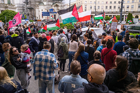 Pro-Palestinian supporters with flags gather during the rally. As April began, the death toll of 32,000 in Gaza was passed, 13,000 of them being children. Pro-Palestinian supporters in Warsaw gathered to show solidarity with the people of Gaza, to protest about the ongoing genocide committed by Israel. The protesters gathered at Plac Zbawiciela and progressed to the Israeli embassy. Fifty meters from the embassy the police prevent the protestors from going any further leading to tensions. Through negotiation, the march was allowed to progress.