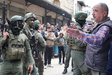 Israeli soldiers speak with a Palestinian man during the army deployment in the Qasaba neighborhood of the Old City market in Nablus. Israeli Amy forces deployed during a security operation in the city's commercial center. An army officer stated that the deployment aimed to assess the situation of merchants and residents in the Nablus market.