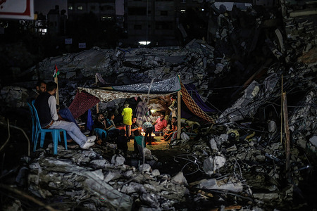 Palestinians seen inside a tent by the rubble of their destroyed house in Beit Hanoun town following the Israel airstrikes in Gaza.Palestinian families started returning to their destroyed houses after 11 days of fighting, a ceasefire came into effect on 21 May between Israel and militants in Gaza strip under an Egyptian initiative for an unconditional ceasefire. At least 232 Palestinians were killed in the Israeli offensive according to Palestinian health ministry, while at least 12 Israelis killed in rocket attacks from Gaza.