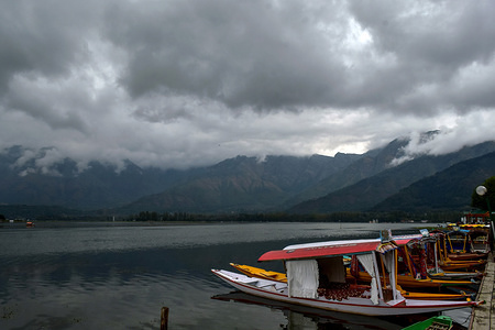 Boats moored to a dock on the bank
of Dal lake during a cloudy day in Srinagar.