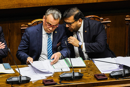 Ricardo Gatica (left), the deputy director of Intelligence, Organized Crime and Migration Security, prefect general (PDI), seen during the Investigative Commission meeting for the case of trafficking of Haitian children. The National Congress of Chile has initiated a specialized Investigative Commission to probe the suspected trafficking and institutional tracking failures regarding Haitian children who entered the country between 2022 and 2025. Launched in response to critical administrative anomalies flagged by the Comptroller General, the parliamentary inquiry seeks to establish political responsibility for the systemic breakdown across border security and migration agencies that left the whereabouts of hundreds of vulnerable minors completely untraceable.