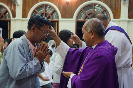 A Catholic priest and a deacon apply ashes to the foreheads of the faithful during an Ash Wednesday Mass at St. Faustina Catholic Church. Myanmar migrants gathered at St. Faustina Catholic Church in Mae Sot to observe Ash Wednesday, marking the start of Lent, 40 days of prayer and fasting for Christians. For many migrants along the Thai-Myanmar border, the church serves as a vital place of worship and community.