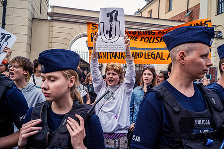 A protestor holds a placard high behind a police cordon during the demonstration. Polish Prime Minister, Donald Tusk of the Civic Coalition, speaks to a rally in Warsaw to promote and campaign for candidates in the upcoming European Parliamentary elections. On the periphery of the gathering, demonstrators protest the previous government's exclusion zone at the Polish-Belarusian border which Tusk has reintroduced.