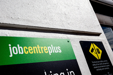 A Jobcentre Plus sign is seen outside its office in central London. The Office for National Statistics reveals that 12.8 % of young adults (16-24 Years old) are not in employment or education. The UK job vacancies fall to the lowest level in five years, outside the pandemic.