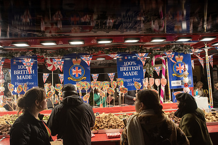 Tourists and shoppers walk front of the Great British Fudge Company's red bus on the Regent Street in London. Thousands of people enjoyed the traffic free Regent Street in London. It was banned for the first time since 2020. It was pedestrianised on Saturday for Christmas shoppers and festive celebrations.