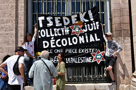 Demonstrators hang a banner from a window grille at Marseille Town Hall during the protest. Activists of the Jewish collective Tsedek demonstrated demanding an end of apartheid by Israel's occupation of Palestine.