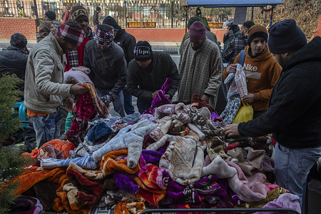 People seen buying warm clothes at a local market during a cold winter day in Srinagar, the capital city of Kashmir.
