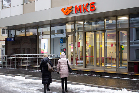 Women walk past an office of the Credit Bank of Moscow. On February 24, the U.S. Treasury Department updated its list of sanctioned Russian banks. Among other banks, the sanctions targeted the Moscow Credit Bank, which is listed among systemically important credit institutions in Russia.