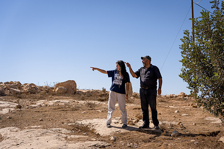 An Israeli activist is seen talking with a resident in the village of Masafer Yatta, which was recently attacked by settlers. Since the start of the war in Gaza, tensions have also escalated in the West Bank, where violence by Israeli settlers against Palestinian residents has sharply increased.