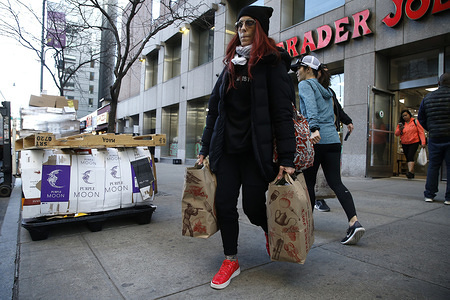 NEW YORK, UNITED STATES - MARCH 21, 2020: A shopper exits a Trader Joes supermarket after stock up on supplies. As the coronavirus (COVID-19) continues to spread throughout the United States, New Yorkers continue with daily routines  limited to shopping and other essential tasks. On March 21, 2020 Governor Andrew Cuomo of New York announced that New York City has become the epicenter of the coronavirus surpassing 10,000 cases.