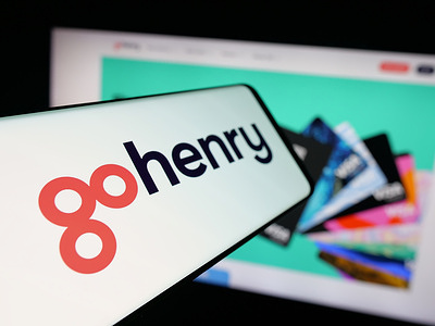 In this photo illustration, a smartphone with the logo of fintech company GoHenry Limited is seen on screen in front of website.