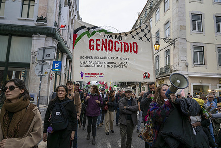 Activists march with a banner during a pro-Palestinian protest. On the occasion of the International Day of Solidarity with the Palestinian People, several social organizations participated in a large solidarity demonstration called “All for Palestine! Stop the genocide! Stop the occupation!” held in the Portuguese capital.