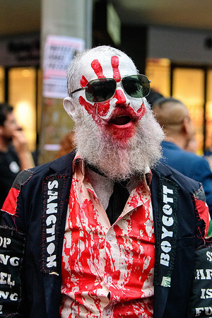 A Pro-Palestinian protester with a blood red hand on his face in Swanston Street during the demonstration. Pro-Palestinian protesters converge on Flinders Street Station in Melbourne, and chanting against the planned visit of the Israeli President later this week. Victoria Police deploy as Members of the Lions of Zion hold a counter-protest outside the National Gallery of Victoria in Melbourne and marched towards the city’s CBD during the evening rallies.